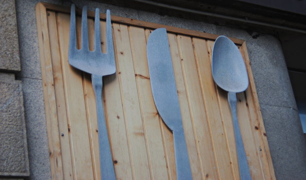 Para comer, talheres pendurados num quadro de metal, faca, garfo, colher