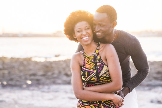 black race african afroamerican couple in relationship or partnership or friendship touching and enjoying the sunset on the beach in vacation outdoor leisure time