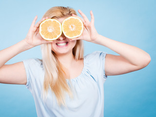 Girl covering her eyes with grapefruits