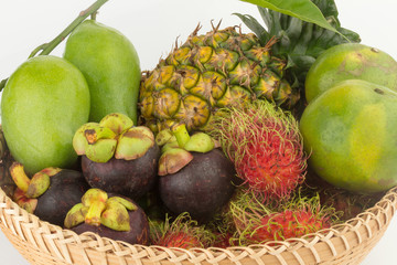 rambutan. pineapple. manggo green. orange green. in basket wood. closeup