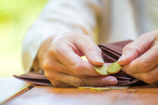 eine Frau sitzt an einem Tisch und z&auml;hlt ihr Geld