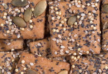 Close view of whole wheat seeded crackers illuminated with natural light.