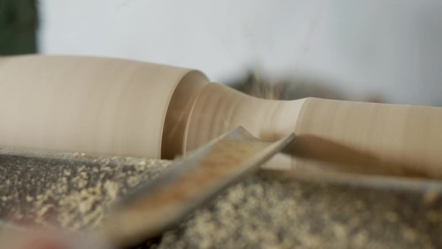joiner turning wood. carving on a lathe. flakes flying. 4k