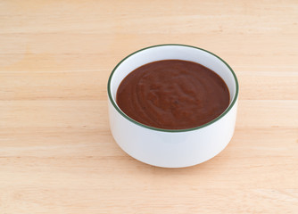Pulled pork starter sauce in a bowl on a wood table.