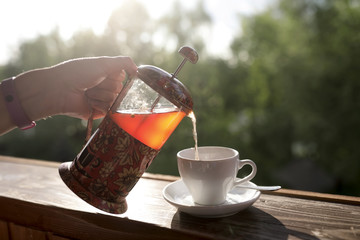 Person pouring tea from french press