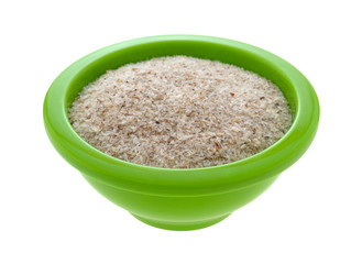 A small green bowl filled with psyllium husks on a white background.