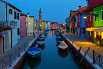 Old colorful houses and boats at night in Burano, Venice Italy.