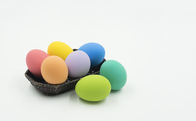 colorful easter eggs in wood basket on isolate background