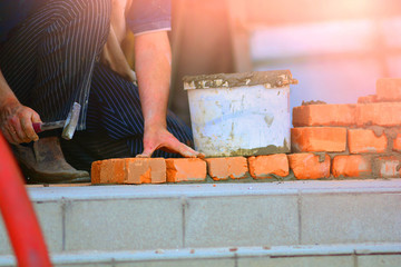 Bricklayer puts a brick for a wall.
