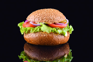 Fresh tasty burger on black background. Tasty and appetizing cheeseburger. Vegetarian burger