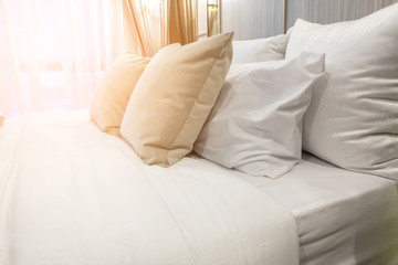 Bed maid-up with clean white pillows and bed sheets in bedroom.