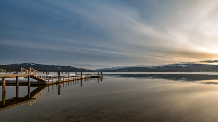 Fototapeta premium Payette Lake sunrise in winter with boat dock in McCall Idaho