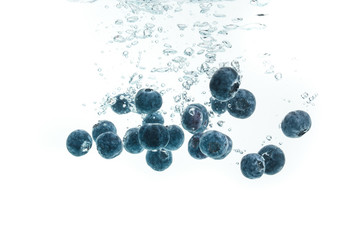 Blueberries falling into water.