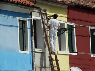Fototapeta na wymiar le peintre sur l'ile colorée de Burano, Venise, Italie