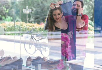Fototapeta na wymiar young couple window shopping at the mall