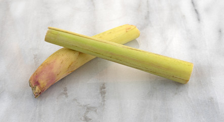 Lemon grass stalks on a gray cutting board.
