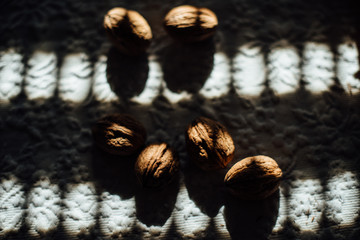 Group of walnuts photographed in the sunlight through blinds