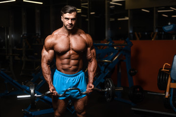 Fototapeta na wymiar Handsome model muscle man abs workout in gym