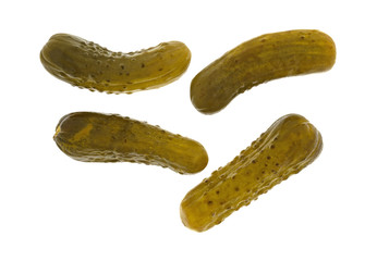 Four kosher baby dill pickles on a white background.