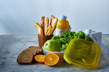 Continental breakfast with fresh pastry, fruits, greenery and beverages over light textured background, top view,