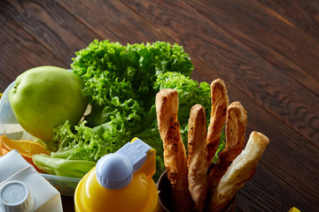 Continental breakfast with fresh pastry, fruits, greenery and beverages over light textured background, top view,
