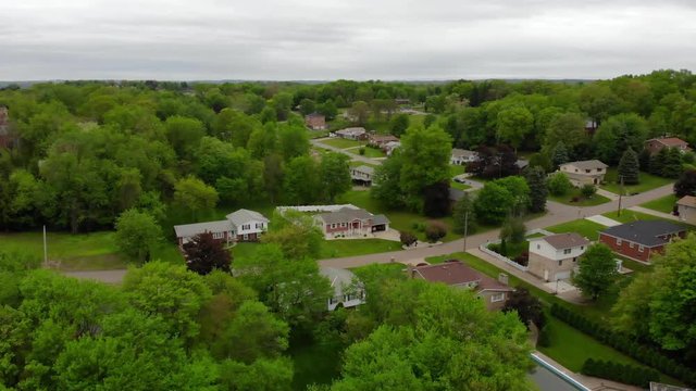 An overcast day aerial establishing shot of a typical Pennsylvania residential neighborhood. Forward moving. Pittsburgh suburbs.  	