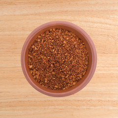 top view of Habanero pepper seasoning in a small bowl atop a wood table.