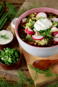 Okroshka with kvass topped with sour cream in a tureen. Traditional meal of the Russian cuisine