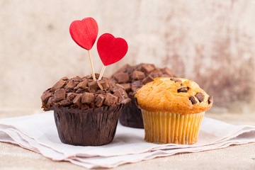 Homemade chocolate muffins with heart, vintage background.
