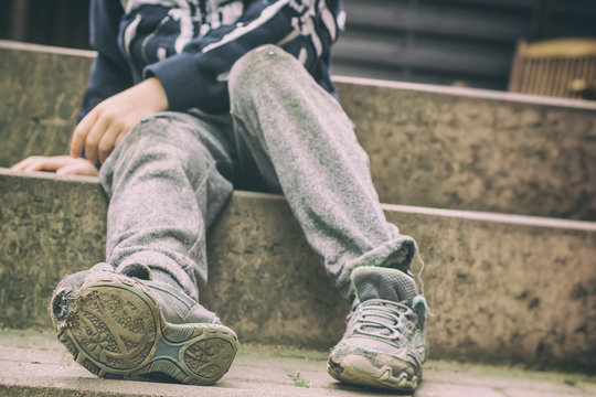 Löchrige Schuhe als Symbol für eine Kindheit in sozialer Benachteiligung