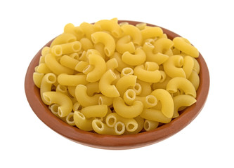 Elbow macaroni in a small red clay bowl isolated on a white background.