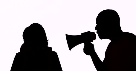 Silhouette of young man scolding a woman using a megaphone in the studio, isolated on white background. Shot in 4k resolution - Powered by Adobe