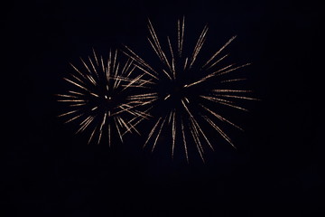 The sparks of the fireworks high in the night sky.
