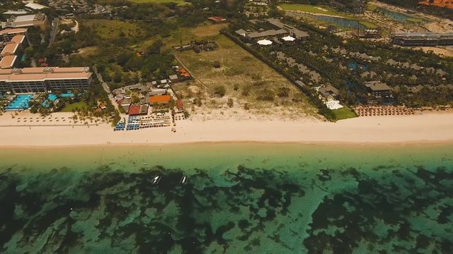 Aerial view of beautiful beach, hotels and tourists, Pura geger, Nusa Dua, Bali, Indonesia. Seascape, beach, ocean, sea 4K video Travel concept Aerial footage