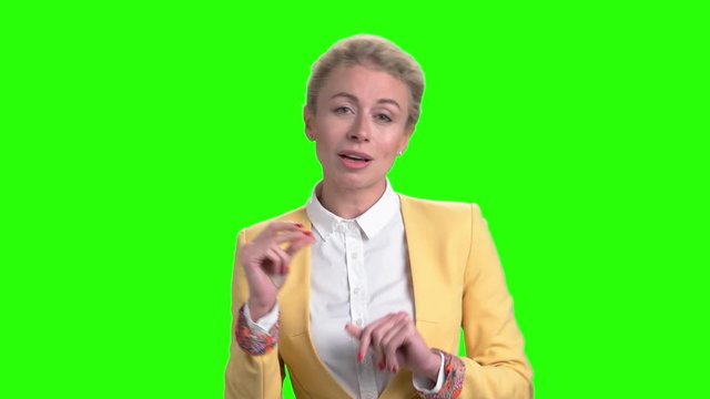 Woman passionately singing on green screen. Joyful lady singing on chroma key background. Pretty cheerful female.