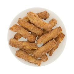 Top view of crunchy baked twisted cookies on a plate isolated on a white background.