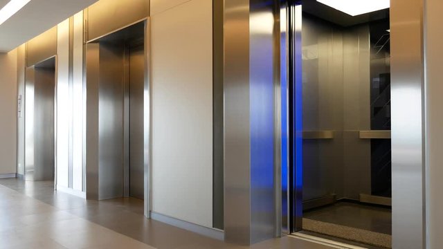Modern steel elevator open and close door cabins in a business lobby or Hotel, Store, interior, office,perspective wide angle. Three elevators in hotel lobby.