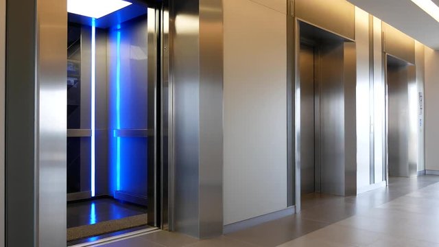 Modern steel elevator open and close door cabins in a business lobby or Hotel, Store, interior, office,perspective wide angle. Three elevators in hotel lobby.