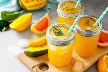 Healthy juicy diet with summer vitamin drinks or a concept of vegetarian food, fresh vitamins, a homemade refreshing fruit drink made of citrus and mango.