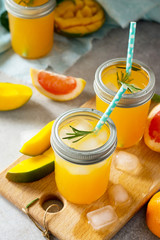 Healthy juicy diet with summer vitamin drinks or a concept of vegetarian food, fresh vitamins, a homemade refreshing fruit drink made of citrus and mango.