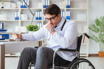 Disabled doctor on wheelchair working in hospital