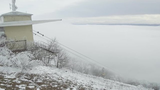 The cab appears from the clouds and slowly approaches the building of the cable station.