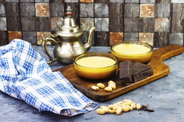 algerian sweet food caramel flan with peanuts and chocolate bars and arabic teapot