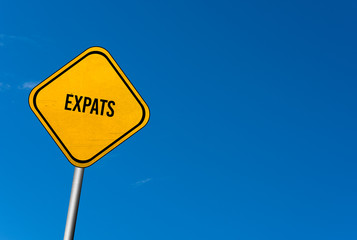 expats - yellow sign with blue sky