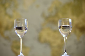Two wineglasses in focus infront of an out of focus map