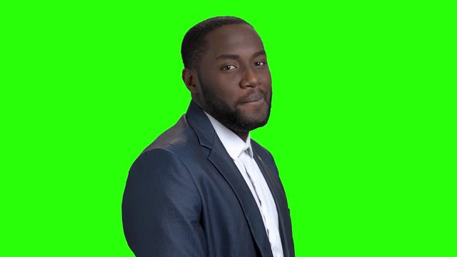 Smiling macho-man on green screen. Portrait of sexy afro-american businessman is flirting on Alpha Channel background. Invitation for a date.