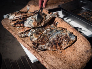 Fototapeta premium Bream cooked on the grill and served on a typical cork tray.
