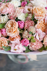 beautiful luxury bouquet of mixed flowers in woman hand. the work of the florist at a flower shop. Vertical photo