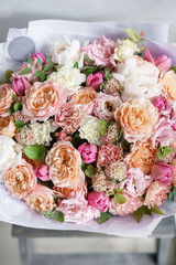 beautiful luxury bouquet of mixed flowers in woman hand. the work of the florist at a flower shop. Vertical photo