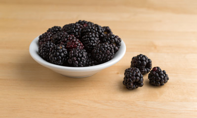 Blackberries in a bowl with fruit to the side
